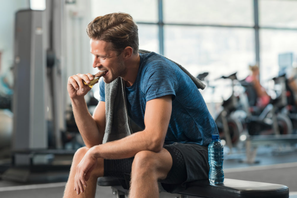 运动员在健身房吃蛋白质棒