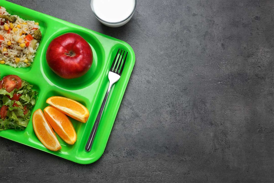 绿色的午餐托盘，苹果，橘子片